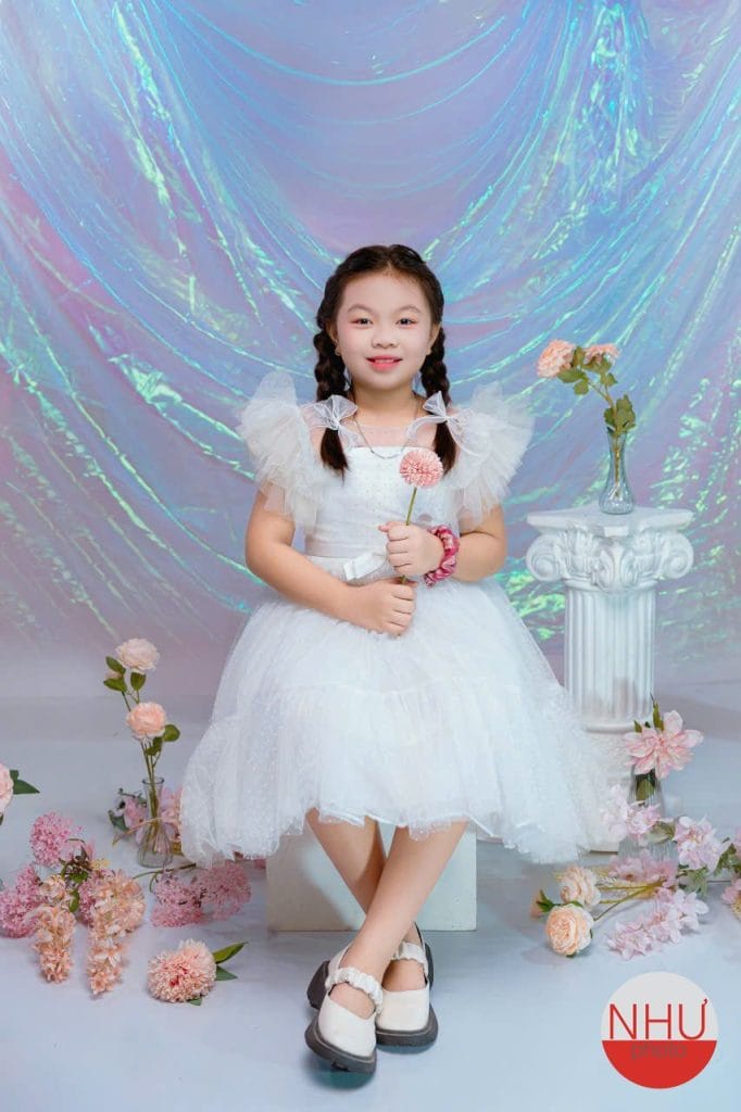 Chụp ảnh khai giảng cho bé gái 6 tuổi váy voan trắng, cầm bông hoa