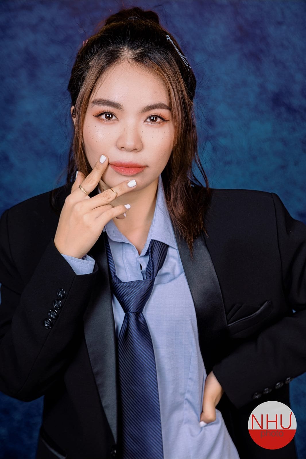 Chụp ảnh thẻ đẹp với áo vest đen và sơ mi xanh trên phông xanh dương