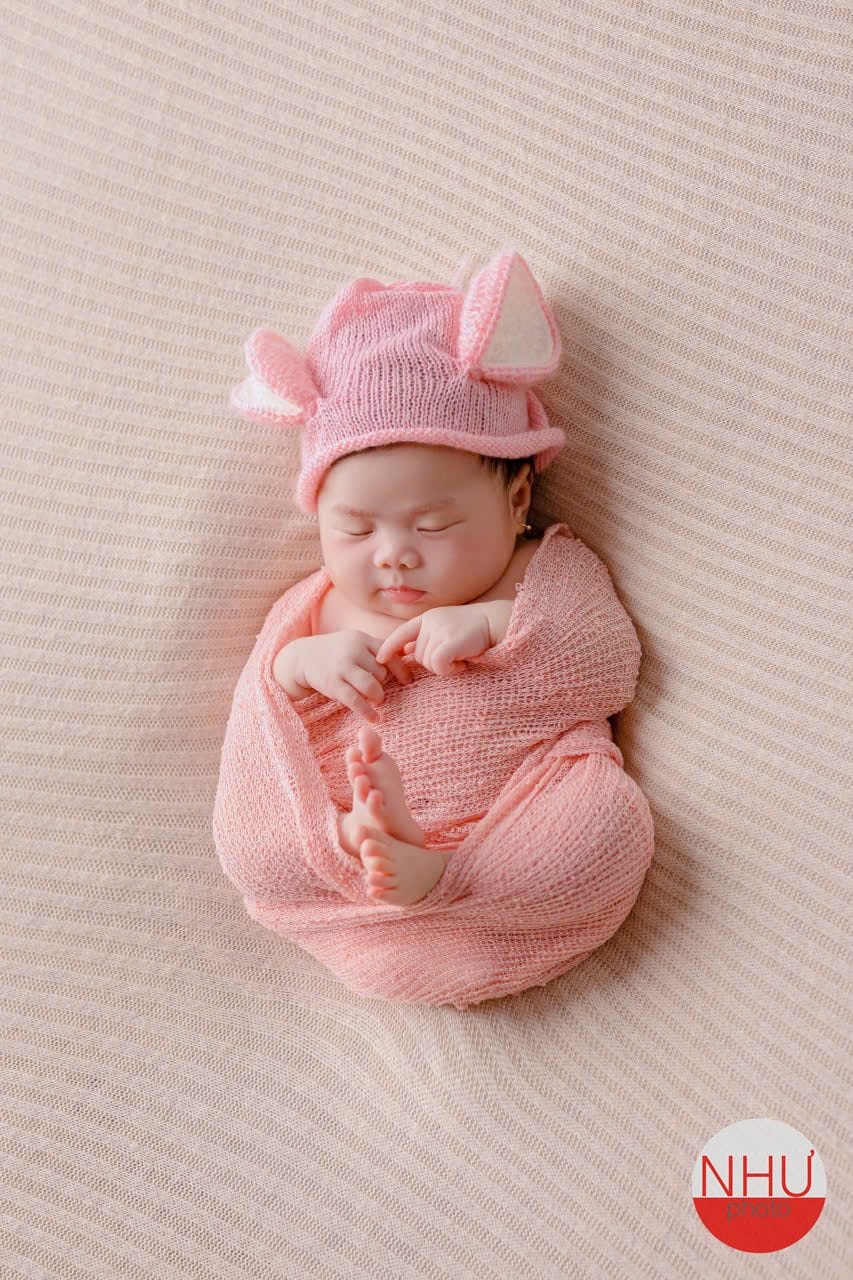 Concept chụp ảnh newborn bé cuộn tròn đội mũ len hồng có tai thú