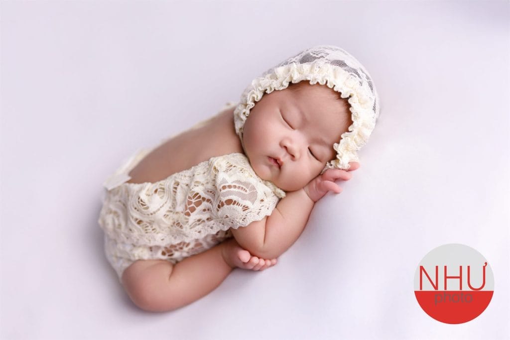 Thời điểm vàng chụp ảnh sơ sinh khi bé ngủ say cuộn tròn trên nền trắng